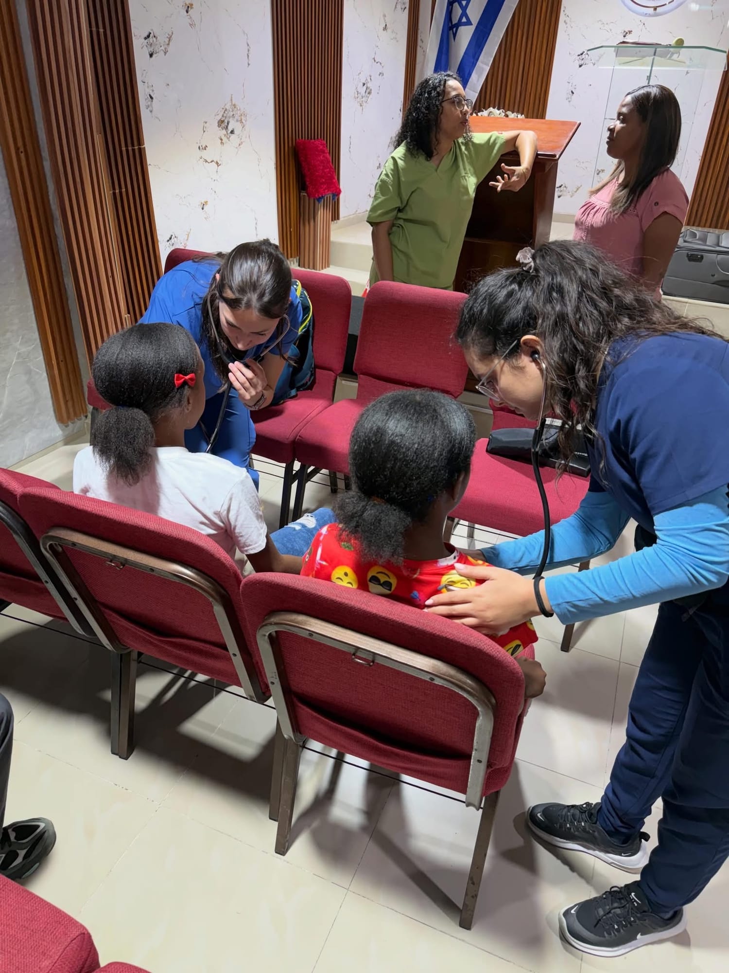 Student clinicians examining young patients in the field