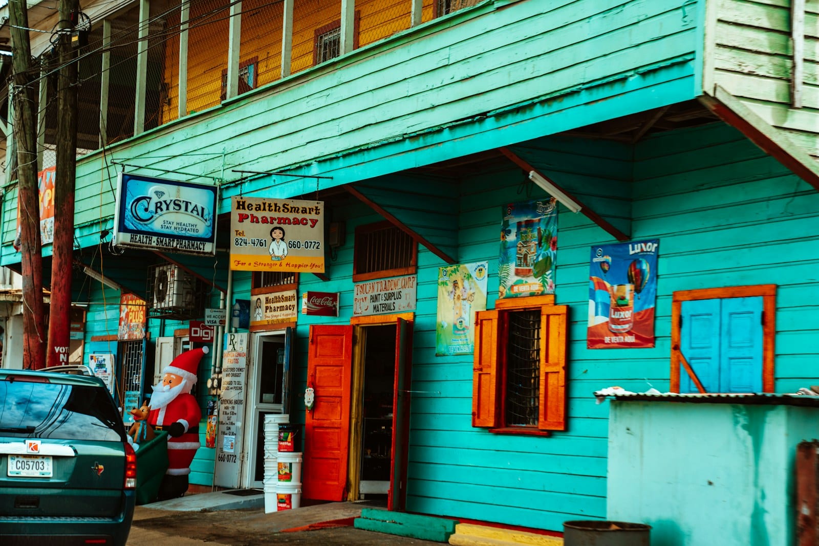 A colorful storefront with a pharmacy on a Belize street
