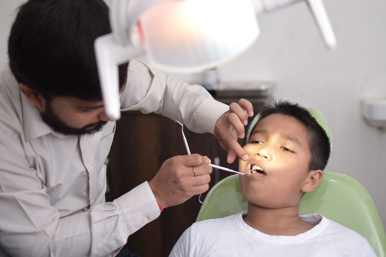 A dentist examining a child's teeth