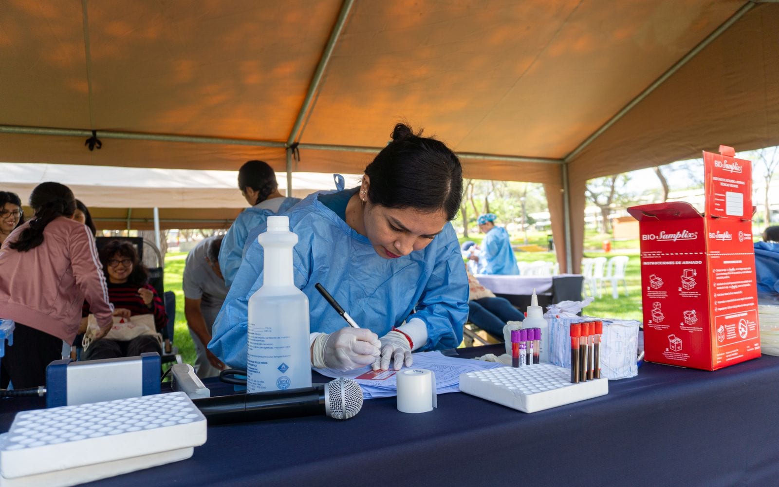A Medicine in Mission volunteer completing paperwork at an outdoor community health event