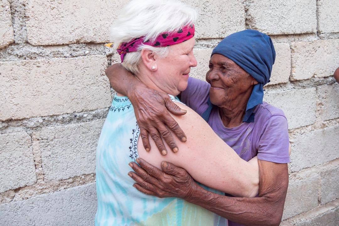 A Medicine in Mission volunteer and an elderly Dominican woman embracing during a mission trip