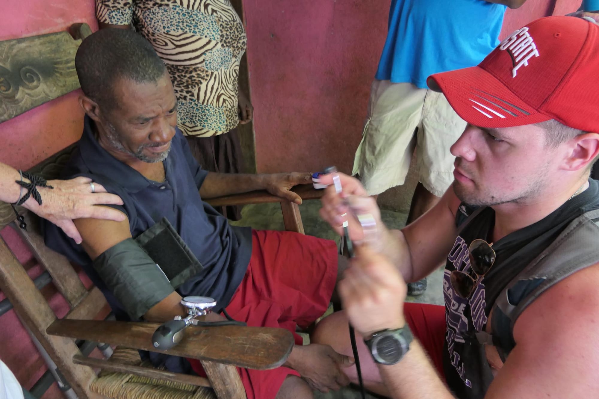 A Medicine in Mission volunteer checking an older patient's blood pressure during a Dominican Republic clinic