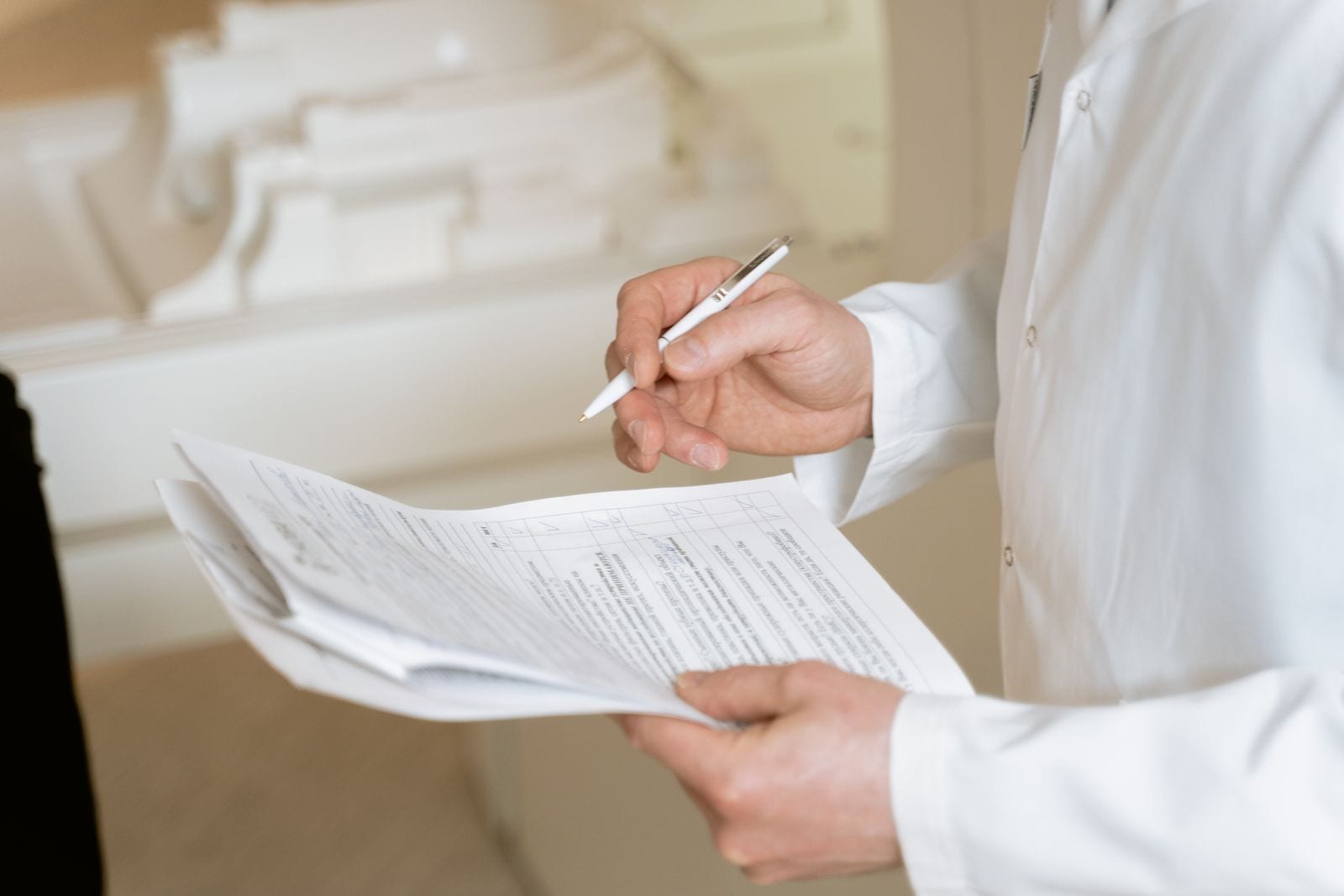 A clinician filling out forms with a pen